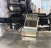 an open step box on a black truck frame in a shop