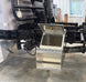an open step box on a black truck frame in a shop