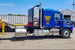 Blue truck with visible branding showing Highway Products step box in an outdoor setting