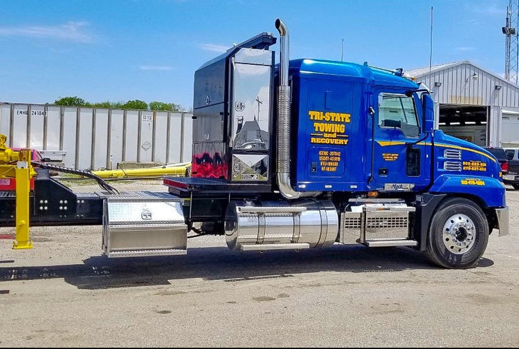 Blue truck with visible branding showing Highway Products step box in an outdoor setting